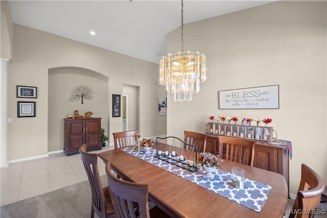 tiled dining space with vaulted ceiling and an inviting chandelier