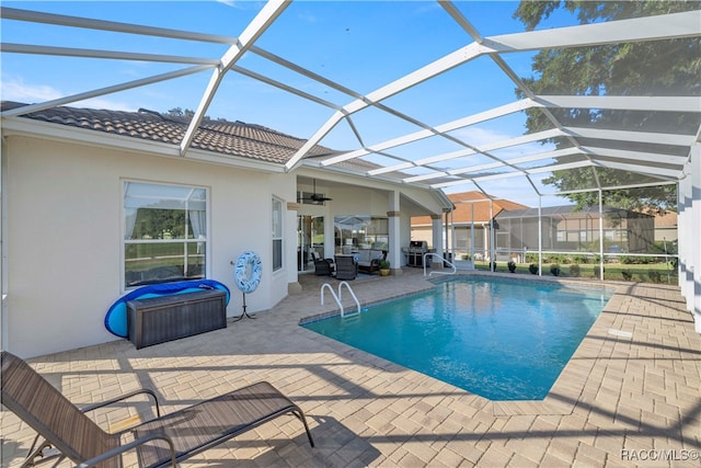 view of swimming pool featuring glass enclosure, ceiling fan, a patio area, and a grill