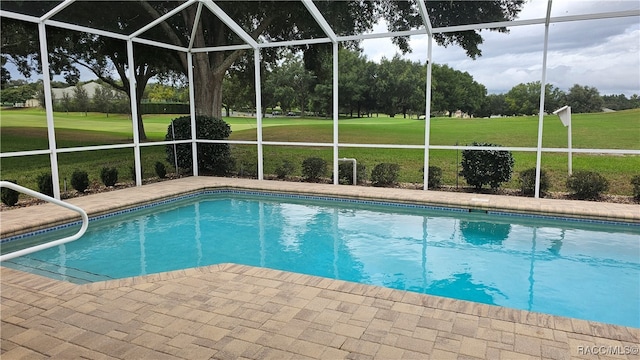 view of pool with a yard, a patio area, and a lanai