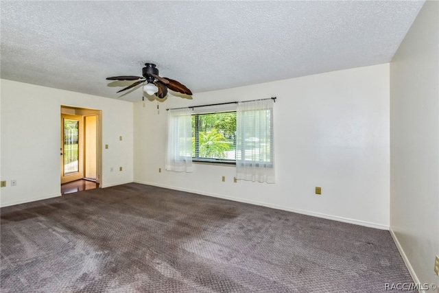 spare room with ceiling fan, a textured ceiling, and dark colored carpet