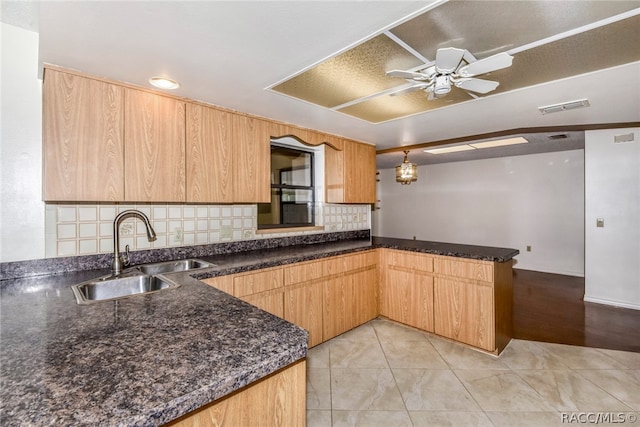 kitchen featuring sink, ceiling fan, tasteful backsplash, decorative light fixtures, and kitchen peninsula