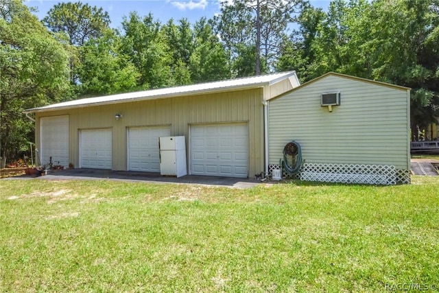 garage with a yard and white refrigerator