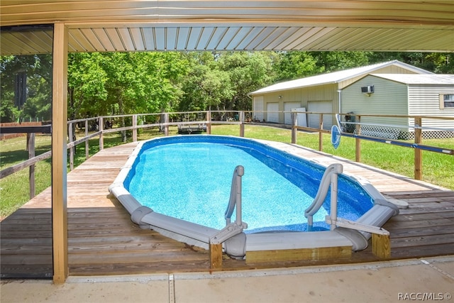 view of pool featuring a garage, a deck, and an outdoor structure