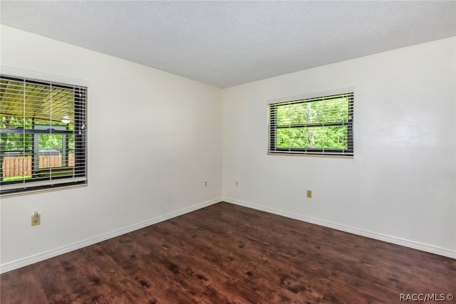 empty room featuring dark hardwood / wood-style flooring and a textured ceiling