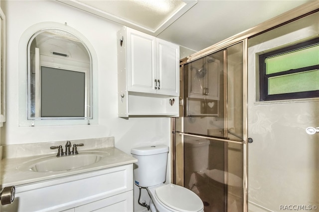 bathroom featuring vanity, an enclosed shower, and toilet