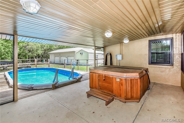 view of swimming pool featuring a patio area and a hot tub