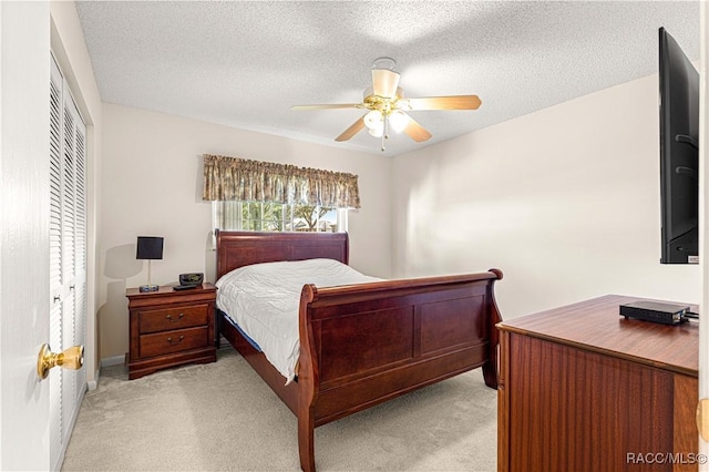 carpeted bedroom featuring ceiling fan, a textured ceiling, and a closet