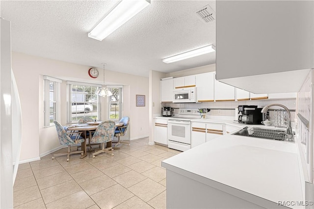 kitchen featuring tasteful backsplash, white appliances, sink, decorative light fixtures, and white cabinetry