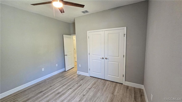 unfurnished bedroom featuring ceiling fan, light hardwood / wood-style floors, and a closet