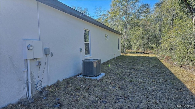 view of home's exterior with central AC unit and a lawn