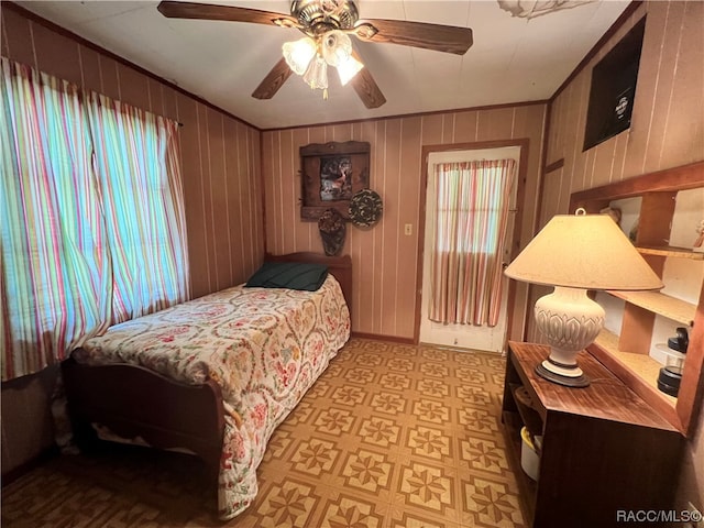 bedroom featuring ceiling fan and wooden walls