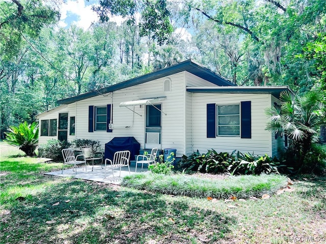 view of front of property featuring a patio area and a front lawn