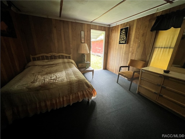 bedroom featuring carpet flooring and wood walls