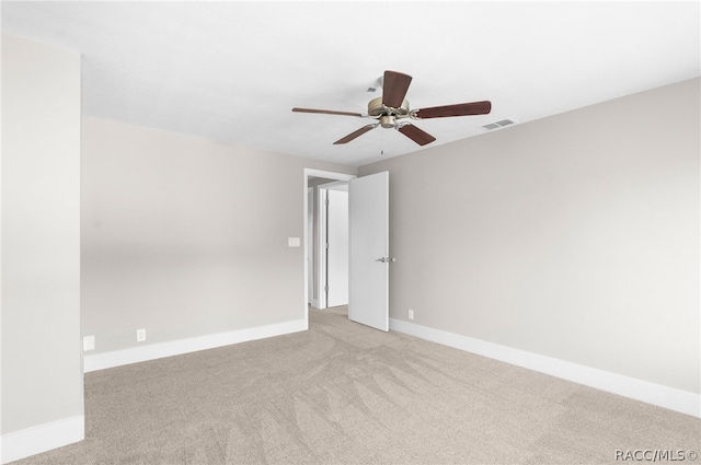 spare room with ceiling fan and light colored carpet