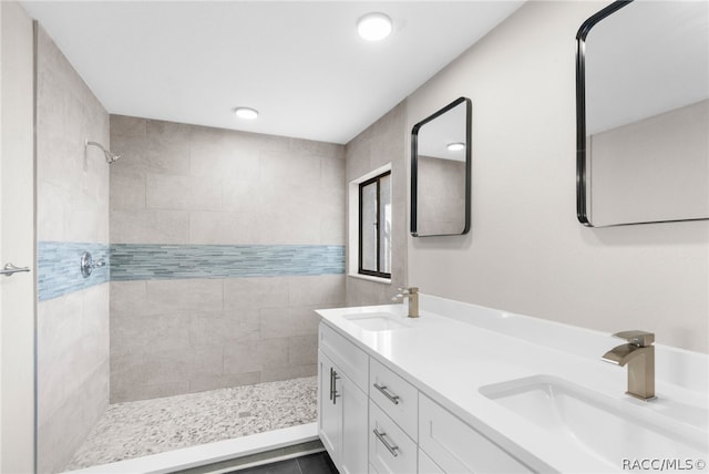 bathroom featuring a tile shower, vanity, and tile patterned floors