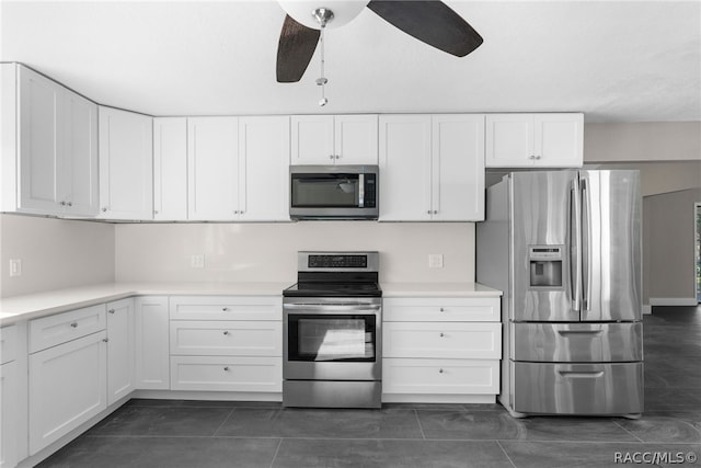 kitchen with dark tile patterned floors, white cabinets, and stainless steel appliances