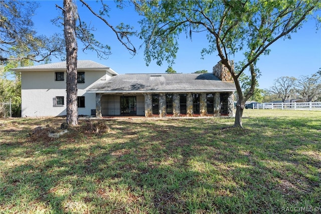 rear view of house featuring a lawn