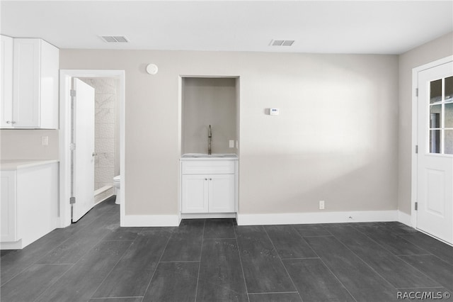 unfurnished room with sink and dark wood-type flooring