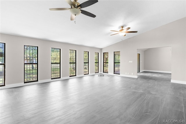 unfurnished living room with ceiling fan and vaulted ceiling