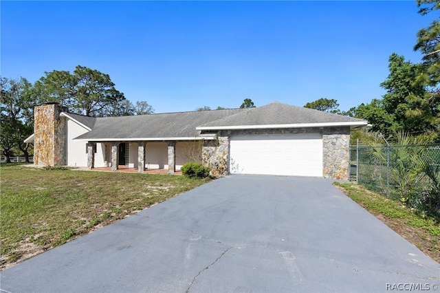 ranch-style house featuring a garage and a front lawn