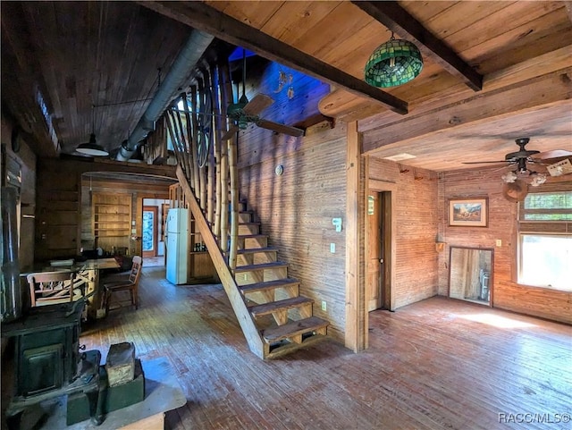 stairs with beamed ceiling, hardwood / wood-style flooring, wooden ceiling, and wood walls