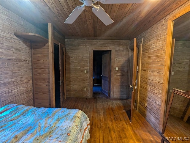 unfurnished bedroom featuring dark wood-type flooring, wood ceiling, ceiling fan, and wood walls