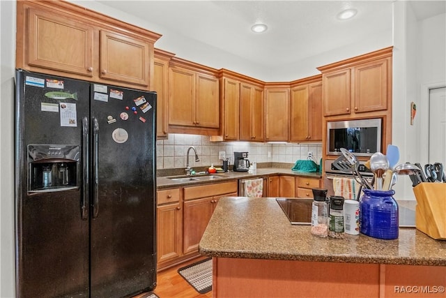 7634 N Hargrove Pt, Crystal River, FL 34428 - kitchen featuring black fridge with ice dispenser, stainless steel microwave, a kitchen island, backsplash, and recessed lighting