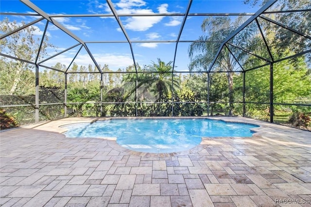 view of swimming pool featuring a lanai and a patio area