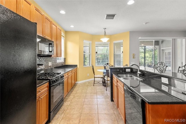 kitchen featuring decorative light fixtures, light tile patterned floors, black appliances, backsplash, and sink