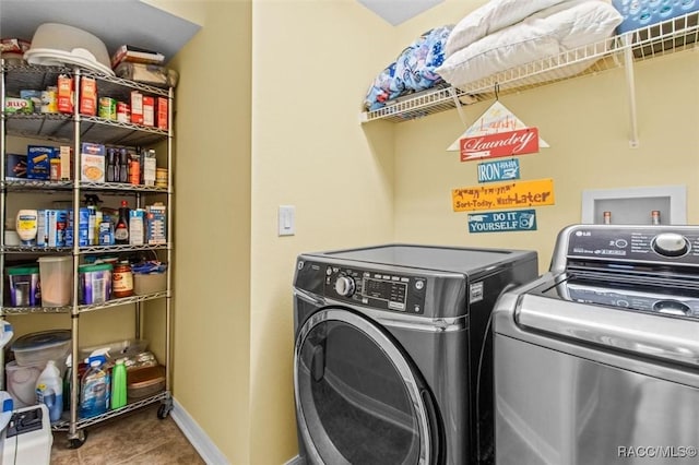 washroom featuring washing machine and dryer and tile patterned flooring