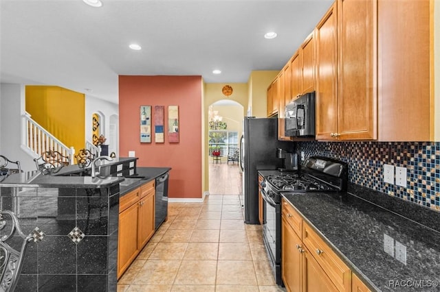 kitchen with black appliances, dark stone counters, decorative backsplash, and light tile patterned floors