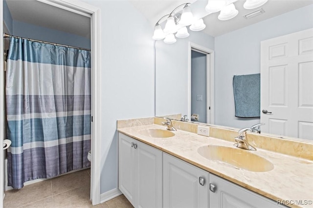 bathroom with tile patterned flooring, vanity, and toilet