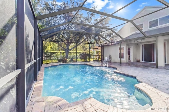 view of pool with pool water feature, a lanai, and a patio