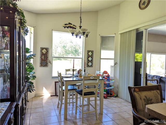 dining room featuring a chandelier, vaulted ceiling, and light tile patterned flooring