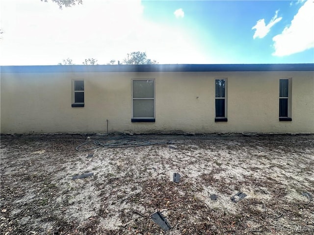 rear view of property featuring stucco siding