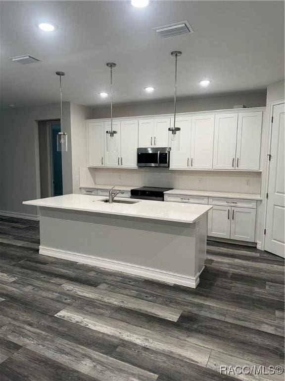 kitchen featuring white cabinetry, sink, pendant lighting, and dark hardwood / wood-style floors