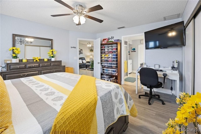 8849 SW 116th Place Rd, Ocala, FL 34481 - bedroom with separate washer and dryer, wood finished floors, a desk, a textured ceiling, and a ceiling fan