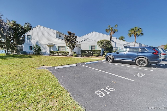 view of parking / parking lot with a lawn