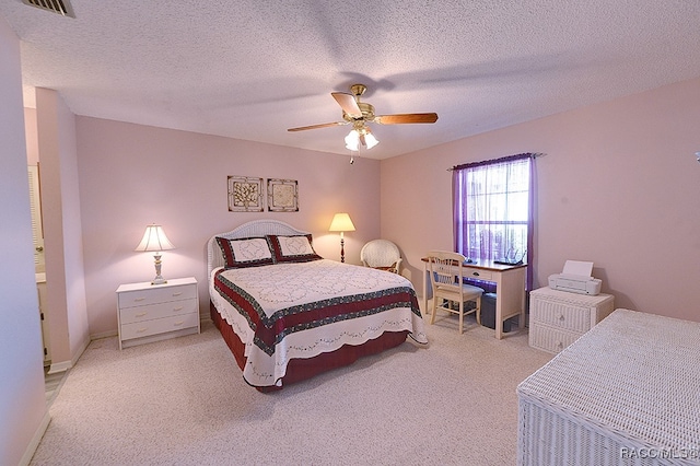 carpeted bedroom with ceiling fan and a textured ceiling