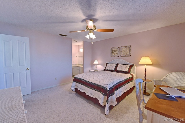 bedroom with connected bathroom, ceiling fan, light colored carpet, and a textured ceiling