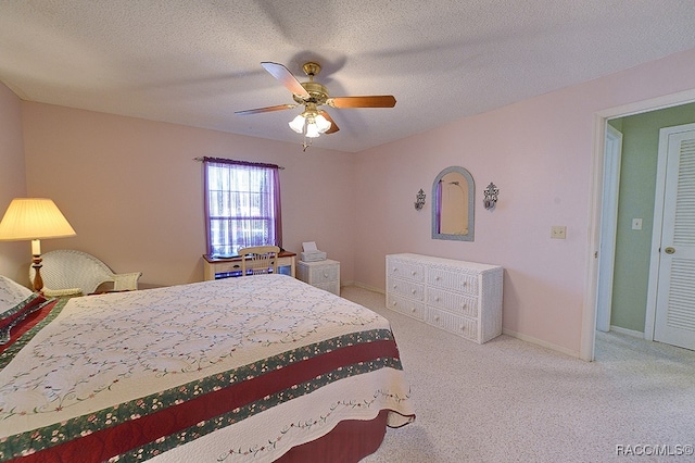 carpeted bedroom with ceiling fan and a textured ceiling