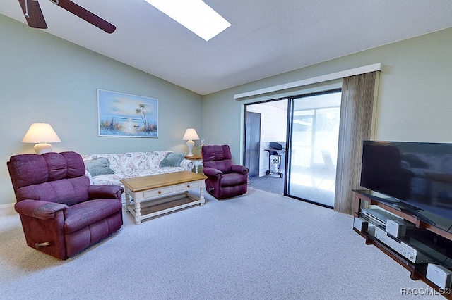 carpeted living room with ceiling fan and vaulted ceiling