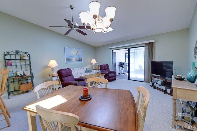 carpeted dining area featuring ceiling fan with notable chandelier and lofted ceiling