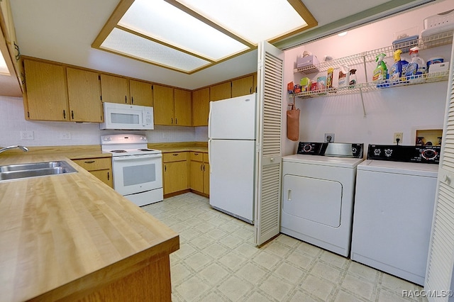 kitchen with sink, washer and dryer, white appliances, and wood counters