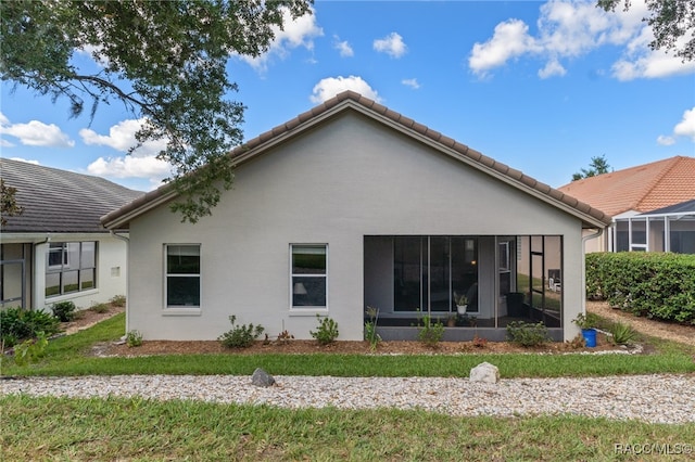 rear view of house featuring a sunroom