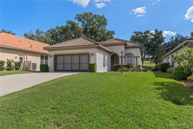 mediterranean / spanish house with a garage and a front yard