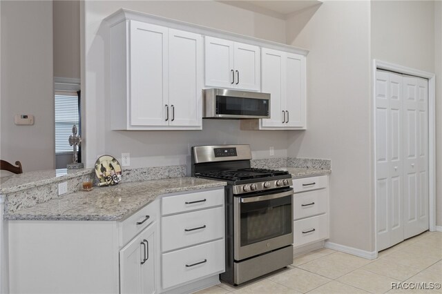 kitchen featuring appliances with stainless steel finishes, white cabinetry, and light tile patterned flooring