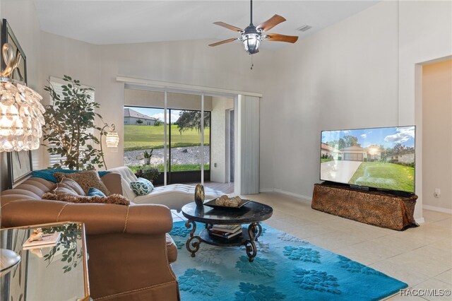 tiled living room featuring ceiling fan and high vaulted ceiling