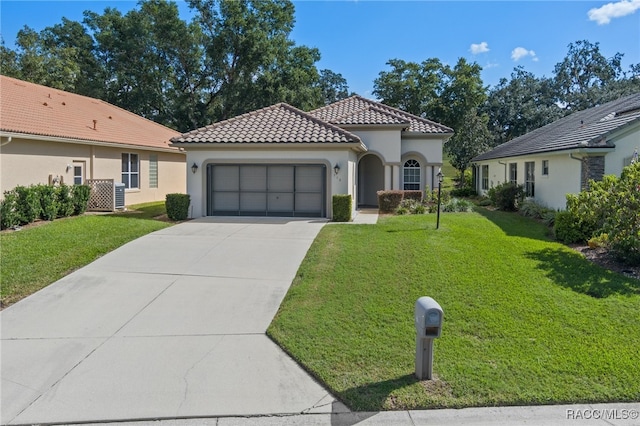 mediterranean / spanish-style house with a front lawn and a garage