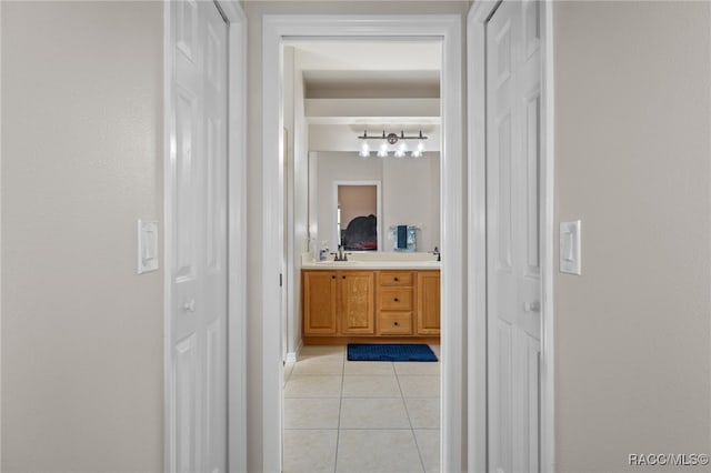 hallway featuring light tile patterned flooring and sink